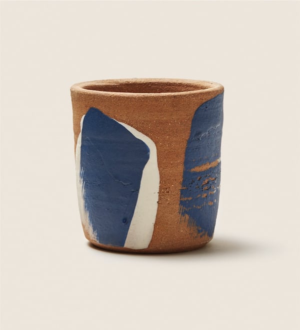 A blue, white, and brown clay cup